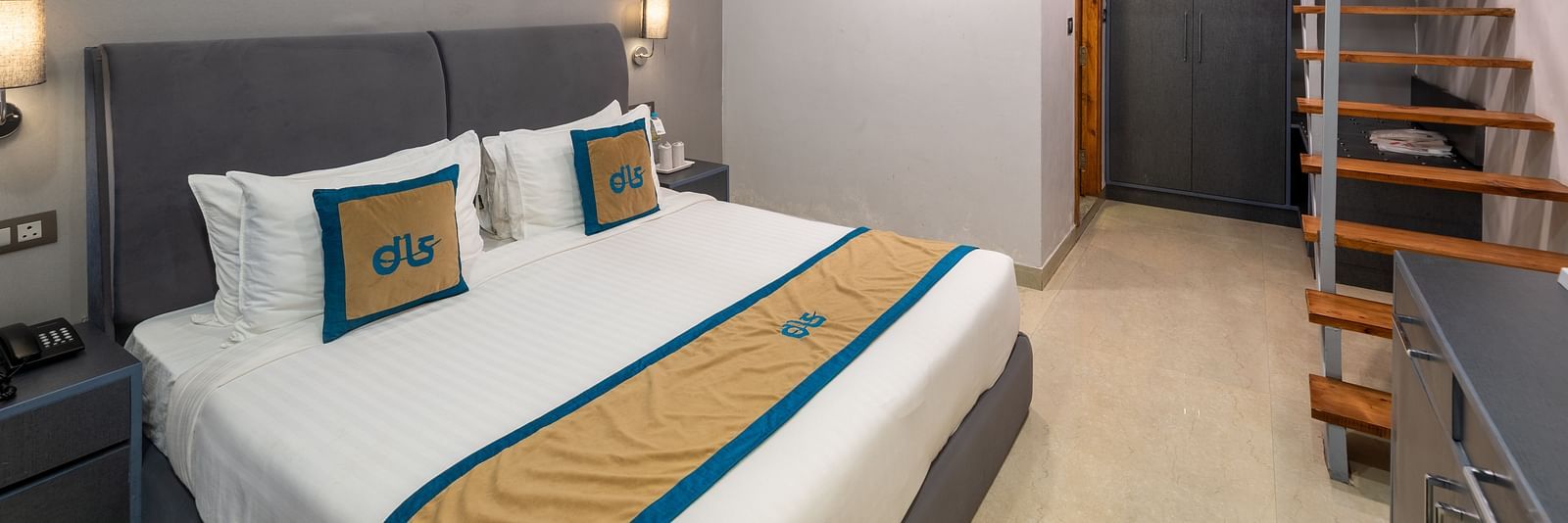 Spring Duplex Room at DLS Spring  Valley resort Dharamshala featuring a king bed table, chairs and stairs leading to second story